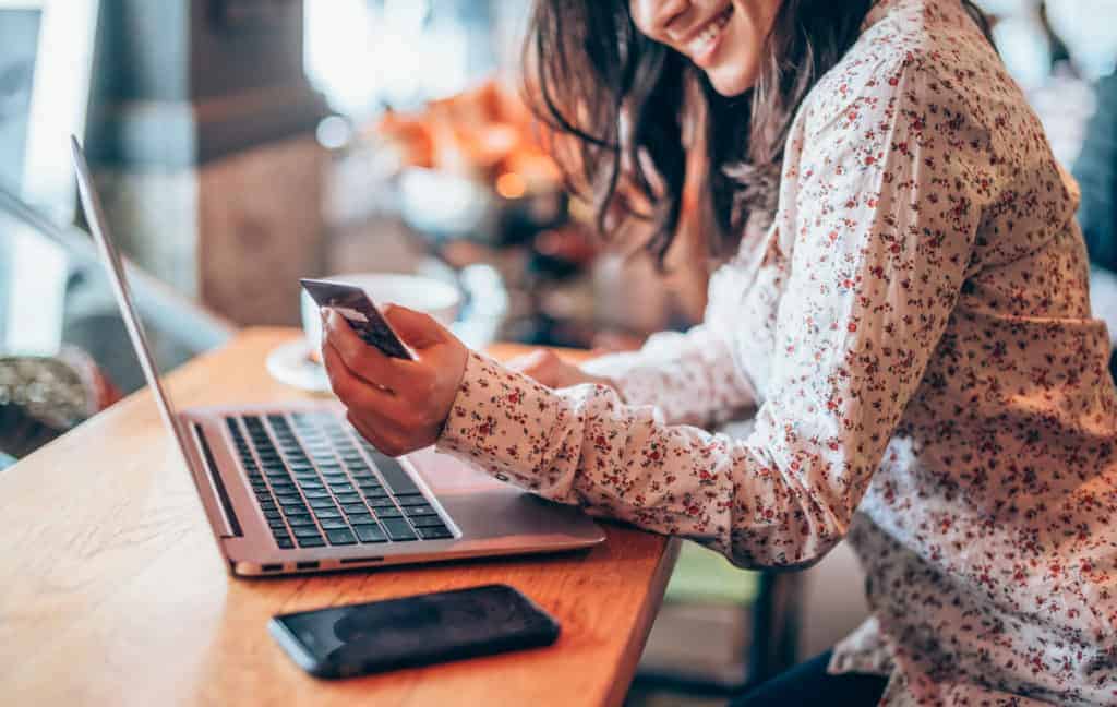 cropped-photo-of-woman-smiling-while-entering-credit-card-information-into-laptop-for-online-shopping-while-seated