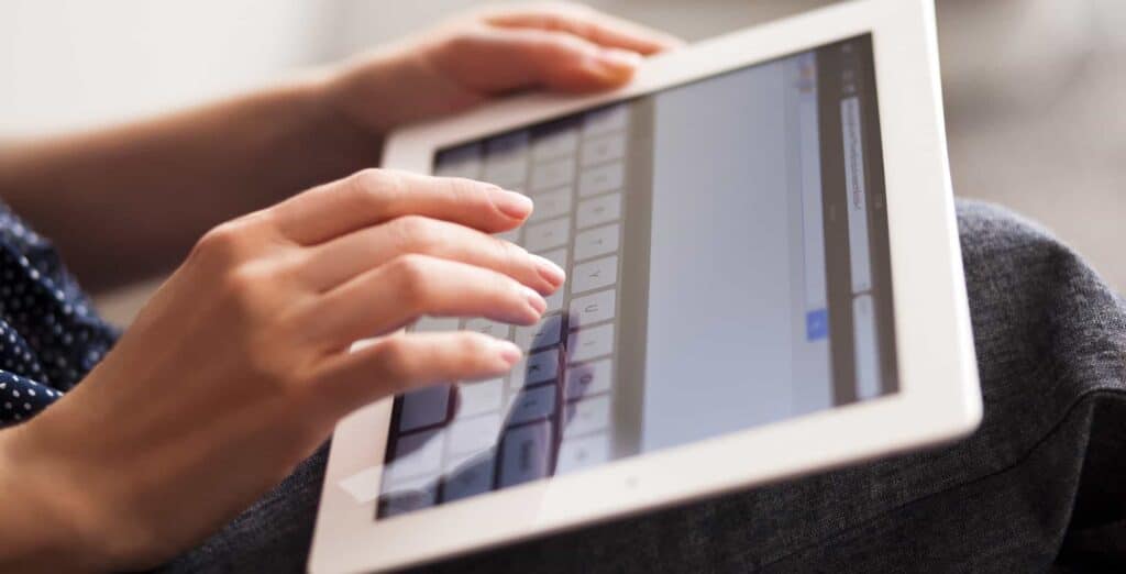 hands-typing-on-ipad-touch-screen-keypad