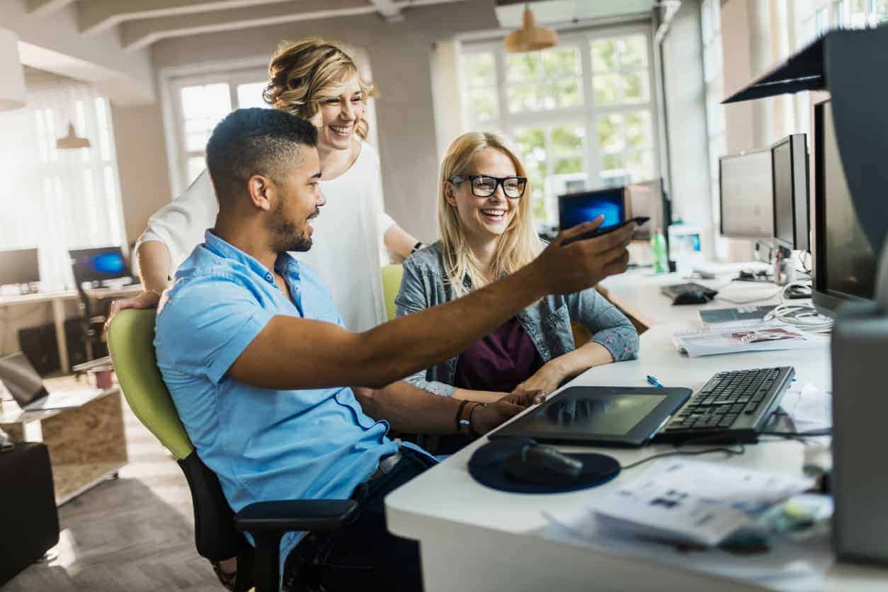 Professionals in an office using computers to work on a business' website hosting.